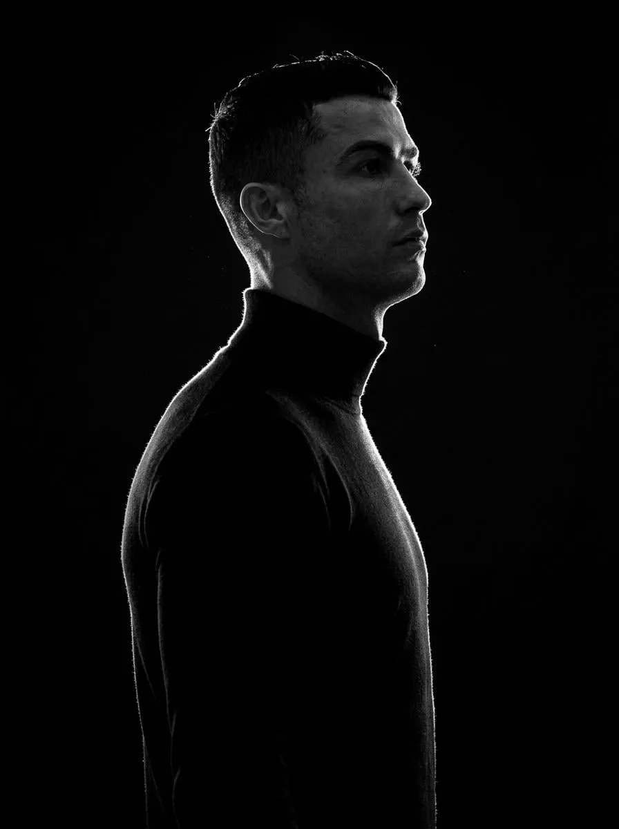 A minimalist black and white cinematic portrait featuring two individuals (male…