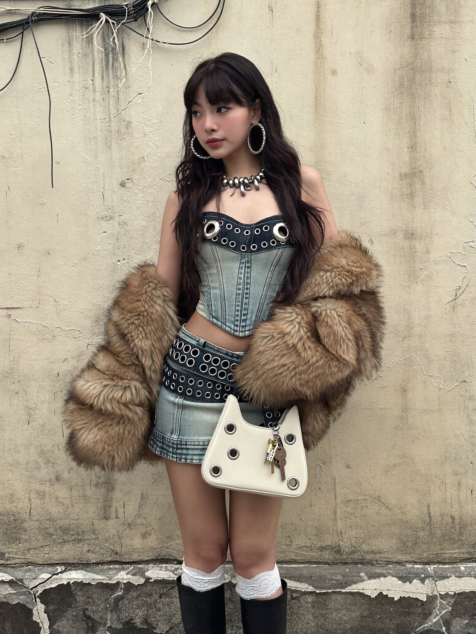 A medium shot captures a young Asian woman in a stylized outfit, standing against a...