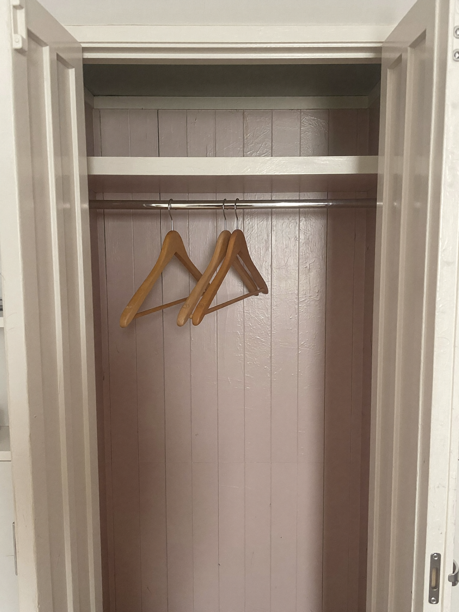 A straight-on view captures the interior of a small closet with open double doors,...