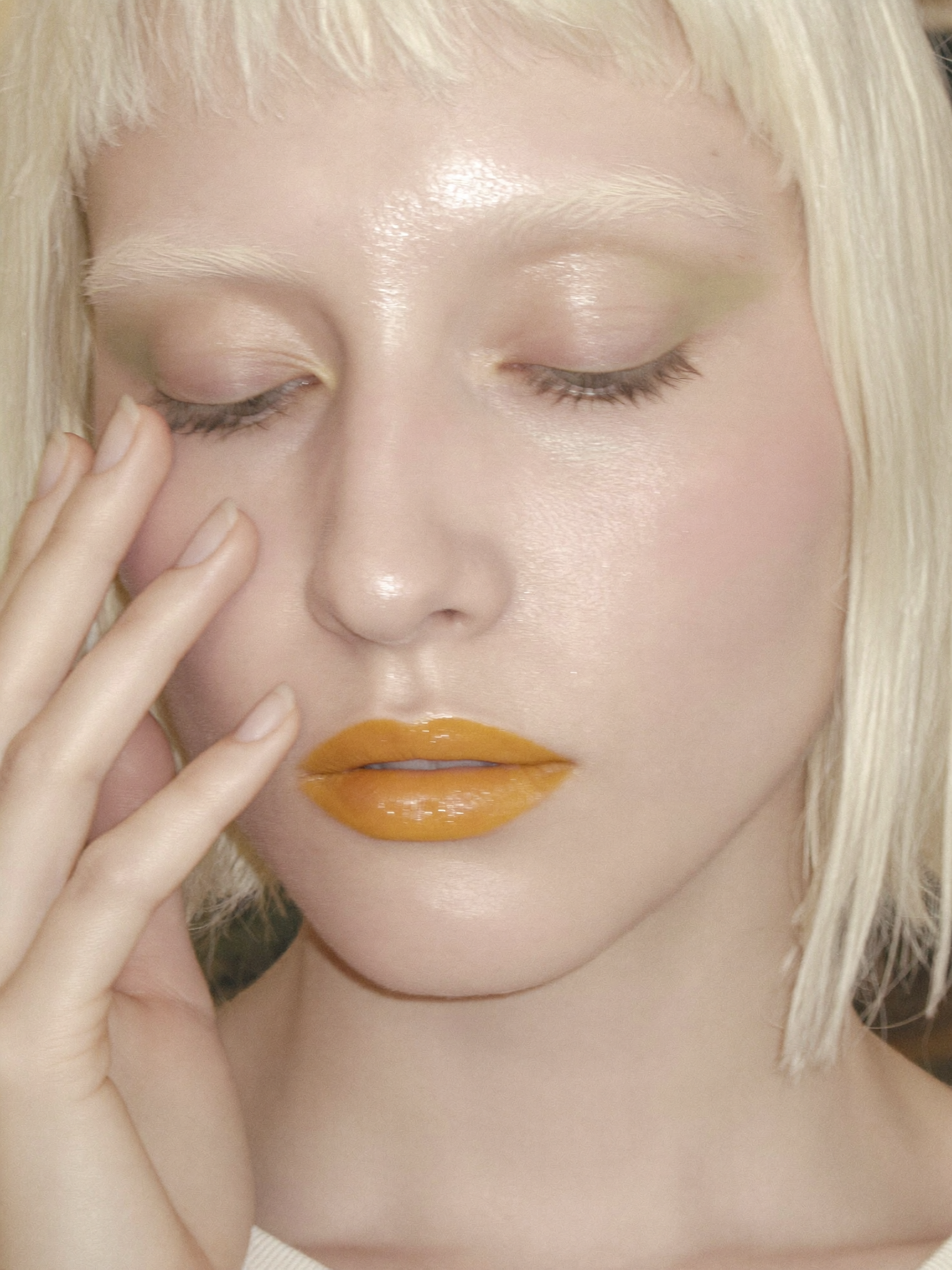 A close-up shot captures a young Caucasian woman with closed eyes, framed slightly...