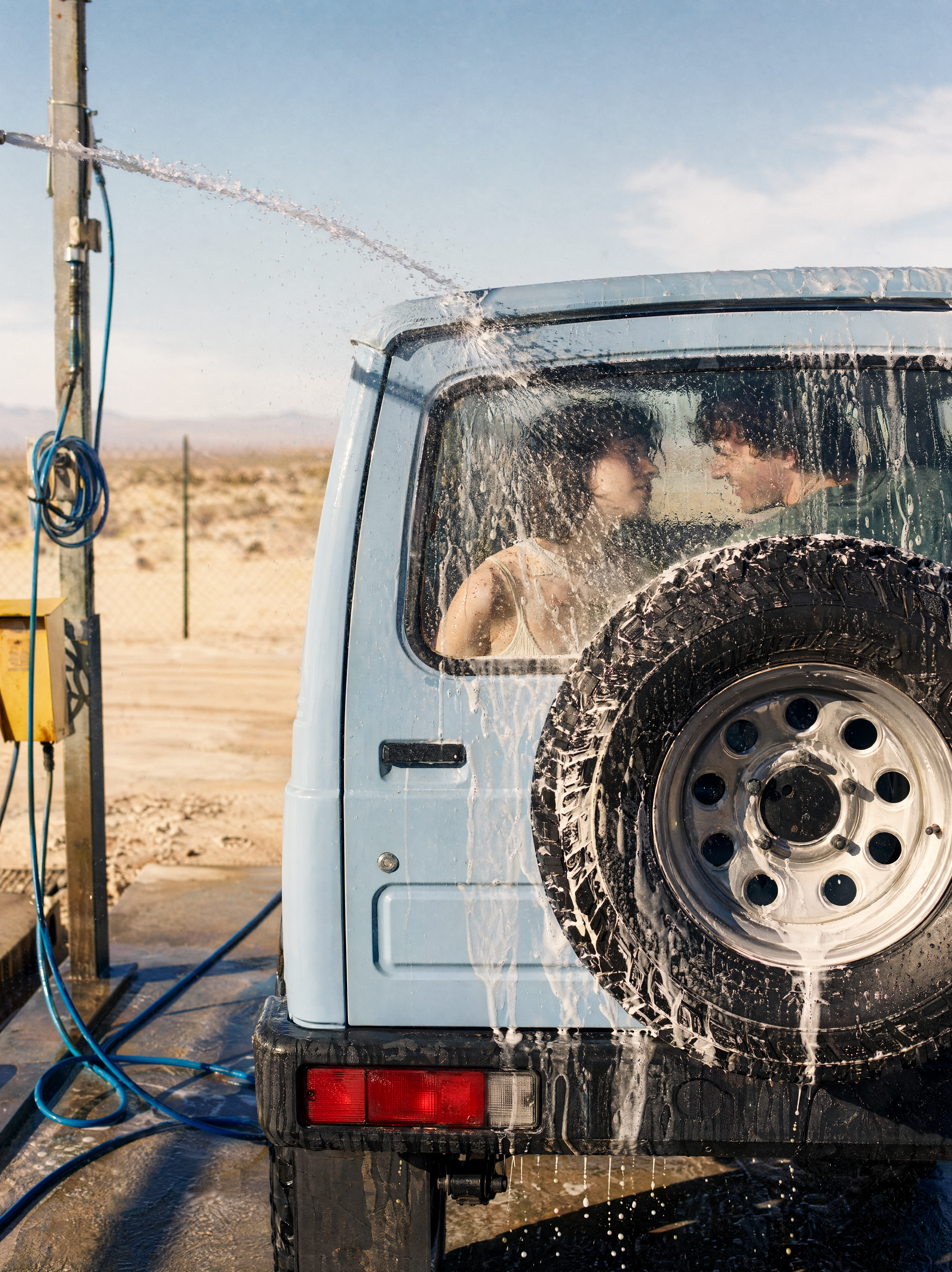 Here's a detailed photo prompt capturing the sun-bleached desert car-wash mood,...